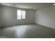 Spacious bedroom with tile floors, neutral paint, and a large window at 17481 W Fulton St, Goodyear, AZ 85338