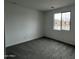 Comfortable bedroom with carpet floors, neutral paint, and a window with a view of the neighborhood at 17481 W Fulton St, Goodyear, AZ 85338