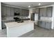 Modern kitchen features gray cabinets, stainless steel appliances, white quartz countertops, and an island with a sink at 17481 W Fulton St, Goodyear, AZ 85338