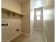 Well-lit laundry room features tile floors, ample shelving, and convenient utility connections at 17505 W Fulton St, Goodyear, AZ 85338
