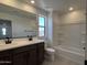 This bathroom features a double vanity, updated fixtures, and a tub with white tile surround at 17511 W Fulton St, Goodyear, AZ 85338