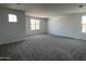 Bedroom with neutral carpet, white walls, and windows offering natural light and neighborhood views at 17511 W Fulton St, Goodyear, AZ 85338