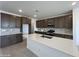 Modern kitchen features dark cabinetry, stainless appliances, and a large island with a sink at 17511 W Fulton St, Goodyear, AZ 85338
