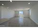 Spacious living room with neutral paint, tile floors, and ample natural light from the windows at 17511 W Fulton St, Goodyear, AZ 85338