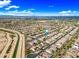 High-angle shot of a neighborhood adjacent to a green canal, showcasing orderly streets and lush green spaces at 18495 W Rimrock St, Surprise, AZ 85388