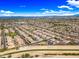 Vast aerial panorama displaying a Primary-planned community with neat rows of homes, bordered by natural landscapes at 18495 W Rimrock St, Surprise, AZ 85388