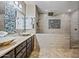 A spacious bathroom features a double vanity, stylish vessel sinks, and a beautifully tiled walk-in shower at 18495 W Rimrock St, Surprise, AZ 85388