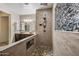 Spacious bathroom with rainfall shower, double sink, wood look tile and tiled shower niche at 18495 W Rimrock St, Surprise, AZ 85388