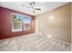 Bedroom with neutral carpet, ceiling fan, large window with blinds, and two-tone walls at 18495 W Rimrock St, Surprise, AZ 85388