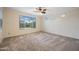 Bright and airy bedroom with large windows, carpeted floors, and a ceiling fan at 18495 W Rimrock St, Surprise, AZ 85388