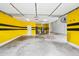 Spacious garage features yellow and black accent walls with ample lighting and room for storage at 18495 W Rimrock St, Surprise, AZ 85388