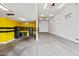 Expansive garage featuring overhead lighting, fan, and a separate storage area with cabinets at 18495 W Rimrock St, Surprise, AZ 85388