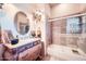 This home features a unique bathroom with a decorative cabinet, a vanity, and a tub shower combo at 19834 W Minnezona Ave, Litchfield Park, AZ 85340