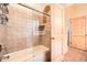 This bathroom features a tub-shower with a glass enclosure, tiled walls, and neutral tones at 19834 W Minnezona Ave, Litchfield Park, AZ 85340