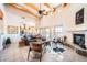 Spacious living room with vaulted ceilings, wood beams, tile floors, and a cozy fireplace at 19834 W Minnezona Ave, Litchfield Park, AZ 85340