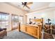 This home features a spacious main bedroom with a ceiling fan, sitting area, and outdoor access at 19834 W Minnezona Ave, Litchfield Park, AZ 85340