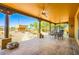 This outdoor patio has a tile floor, fans, posts, and a backyard view with trees and desert plants at 19834 W Minnezona Ave, Litchfield Park, AZ 85340
