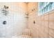 Modern shower with dual showerheads, built-in shelving, and a glass block window for natural light at 19834 W Minnezona Ave, Litchfield Park, AZ 85340