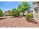 Backyard features desert landscaping with mature trees and a covered patio, offering a serene outdoor space at 20215 N Mariposa Way, Surprise, AZ 85374