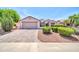 Charming single-story home with manicured landscaping, a two-car garage and a brick-paved driveway at 20215 N Mariposa Way, Surprise, AZ 85374