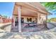 Charming covered patio with a dining area and a seating arrangement with lush landscaping adding beauty at 20215 N Mariposa Way, Surprise, AZ 85374