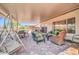 Expansive covered patio featuring a swing, dining area, and lounge space, ideal for outdoor living at 20215 N Mariposa Way, Surprise, AZ 85374