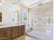 Beautiful bathroom features a double vanity, luxurious glass shower with a built-in bench, and elegant tile flooring at 20615 W Daniel Pl, Buckeye, AZ 85396