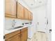 A modern laundry room featuring cabinets, a stainless steel sink, and new appliances at 20615 W Daniel Pl, Buckeye, AZ 85396