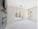 The carpeted living room with a tile fireplace and sliding glass doors to the outdoors at 20615 W Daniel Pl, Buckeye, AZ 85396