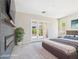 Bright main bedroom features an electric fireplace, plush carpet, and access to the outdoor space through glass paneled double doors at 20615 W Daniel Pl, Buckeye, AZ 85396