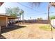 Large backyard featuring a patio area, a dirt area, tall privacy fence, and partial shade at 2064 W 2Nd St, Mesa, AZ 85201