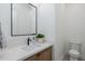 Elegant powder room featuring a stylish vanity with modern fixtures and a decorative mirror at 2087 N 77Th Pl, Mesa, AZ 85207