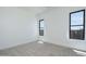 Carpeted bedroom with a large window, white walls, and baseboards providing a clean and modern look at 2087 N 77Th Pl, Mesa, AZ 85207