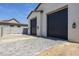 Exterior view of the garage featuring dual, dark-colored garage doors and paved driveway entrance at 2087 N 77Th Pl, Mesa, AZ 85207