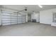 Clean, spacious garage with overhead door, neutral color scheme and plenty of room for storage or parking at 2087 N 77Th Pl, Mesa, AZ 85207
