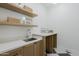Well-equipped laundry room with built-in shelves and a sink for added convenience and storage at 2087 N 77Th Pl, Mesa, AZ 85207