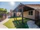 Back patio area with a wooden pergola and artificial grass for easy maintenance and outdoor enjoyment at 2107 E Park Ave, Gilbert, AZ 85234