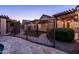 Backyard featuring decorative pavers, a secure wrought iron fence, a pergola, and lovely lighting, creating an inviting outdoor space at 2107 E Park Ave, Gilbert, AZ 85234