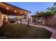 Inviting backyard featuring an outdoor patio with string lights, lush artificial grass, and a secure fenced pool area at 2107 E Park Ave, Gilbert, AZ 85234