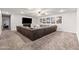 Spacious basement with a large sectional couch, flat screen TV, and carpet flooring at 2107 E Park Ave, Gilbert, AZ 85234