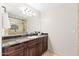 Bathroom featuring a dark wood vanity, a large mirror, and a tiled shower at 2107 E Park Ave, Gilbert, AZ 85234