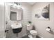 Stylish half bath with modern fixtures, patterned floor tiles, custom mirror, and unique wall art at 2107 E Park Ave, Gilbert, AZ 85234
