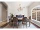 Formal dining room featuring a decorative chandelier, accent wall, and large windows at 2107 E Park Ave, Gilbert, AZ 85234