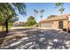 Long driveway showcasing a lush, landscaped lawn and a home with mature palm trees at 2107 E Park Ave, Gilbert, AZ 85234