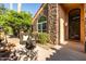Charming front patio with stone accents, wicker furniture, and a lush garden view at 2107 E Park Ave, Gilbert, AZ 85234
