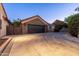 A spacious three-car garage boasts stone accents and custom doors at 2107 E Park Ave, Gilbert, AZ 85234