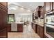 This kitchen features wood cabinets, stainless steel appliances, stone countertops and an open view to the dining room at 2107 E Park Ave, Gilbert, AZ 85234