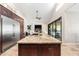 View of kitchen featuring island with sink, stainless fridge, travertine floor and opens to Gathering room at 2107 E Park Ave, Gilbert, AZ 85234