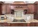 Detailed shot of granite countertop, mosaic backsplash, dark wood cabinets, and stainless steel appliances at 2107 E Park Ave, Gilbert, AZ 85234