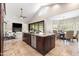 This open kitchen features a large center island, stainless steel appliances, stone countertops and an adjacent living room at 2107 E Park Ave, Gilbert, AZ 85234